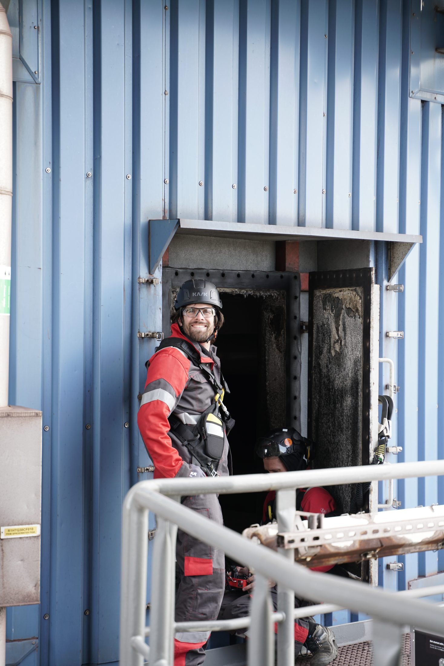 Smiling pilot at a boiler manway entry