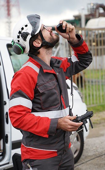 Dries Speybrouck holding a caged Elios drone at a vessel manway